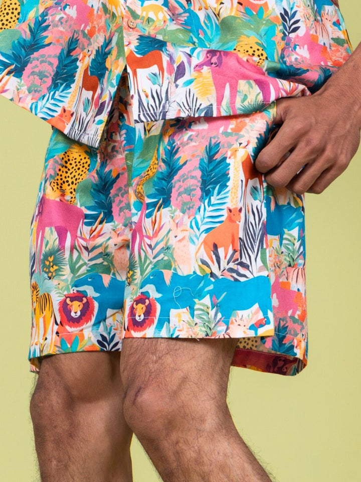 Colorful animal print shirt and shorts on a person against a light green background