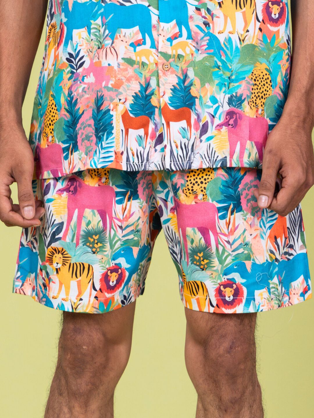 Colorful animal-patterned mens cotton shorts against a light green background