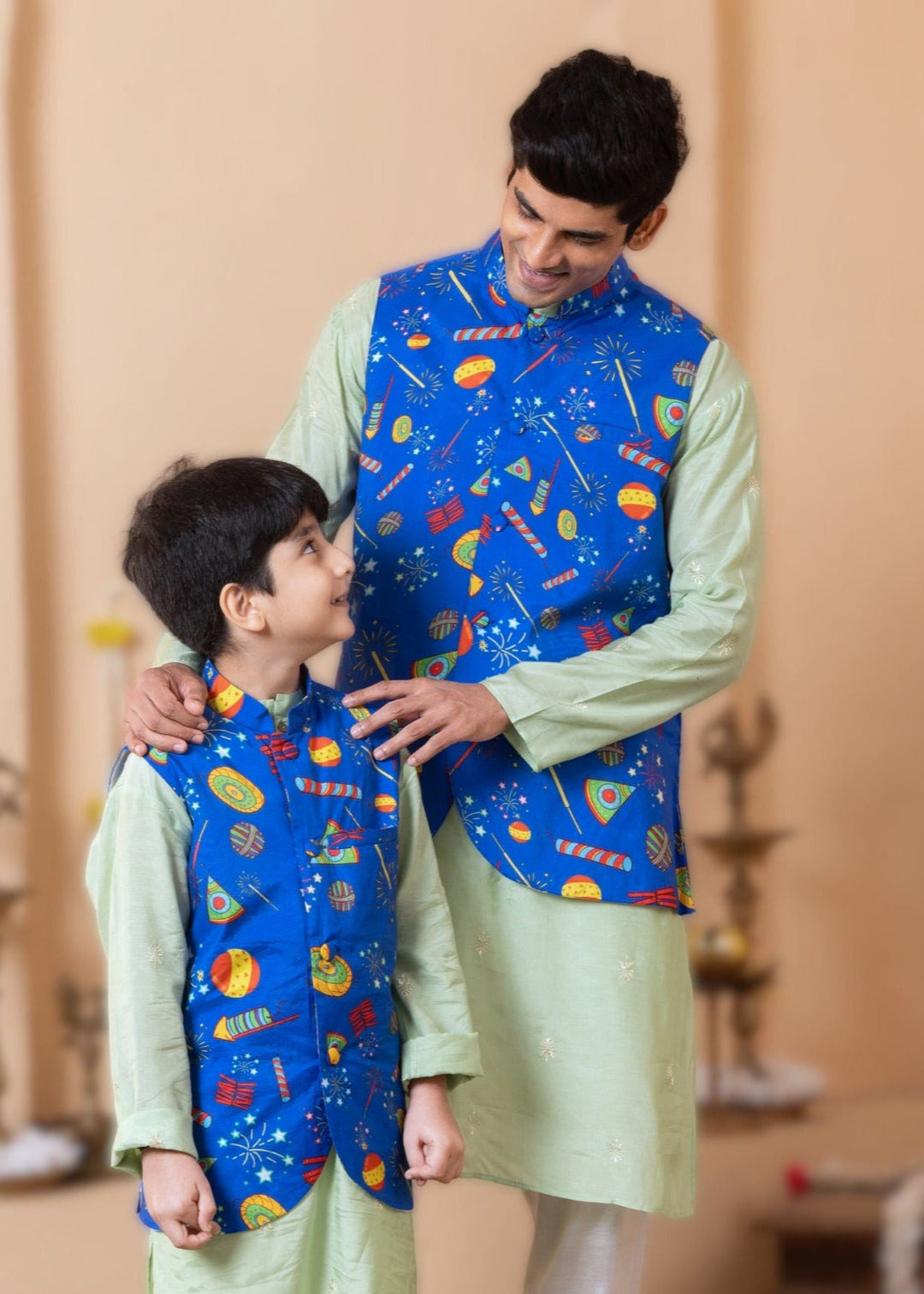 father and son twin and match with each other in a blue nehru jacket with diwali fireworks print