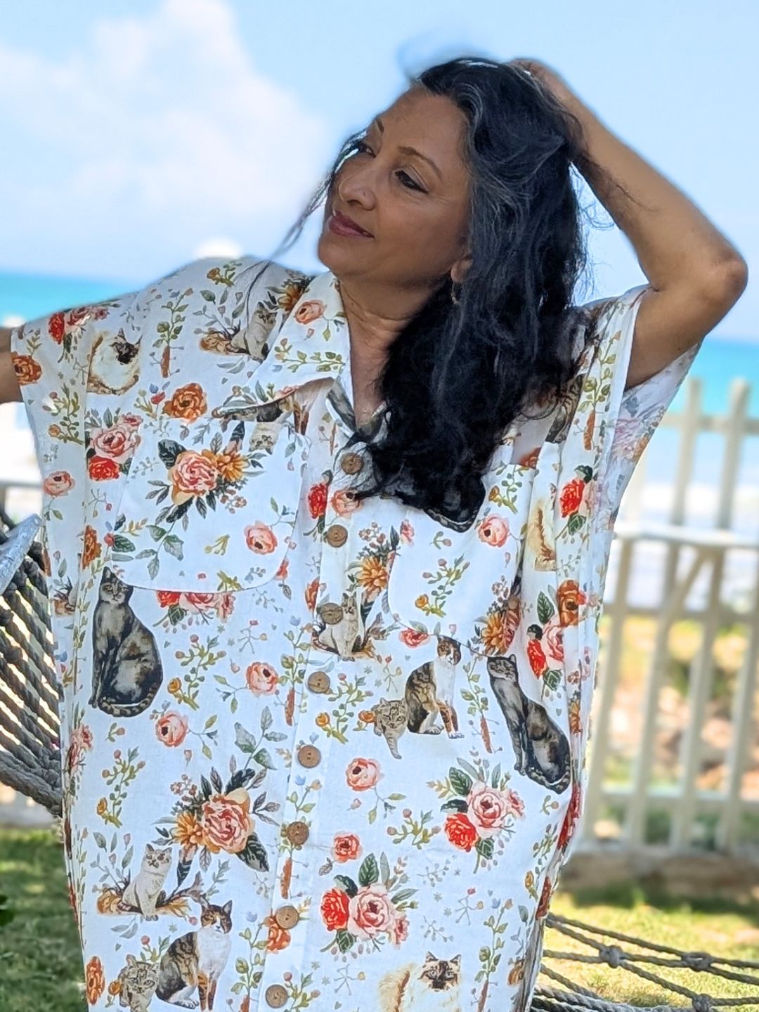 Woman wearing a floral and cat-patterned no bra loungewear outdoors.