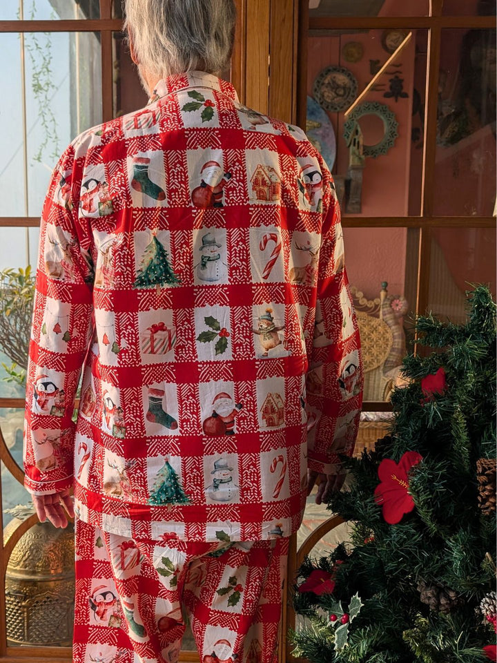 Person wearing a red and white patterned night suit in a room with a Christmas tree.