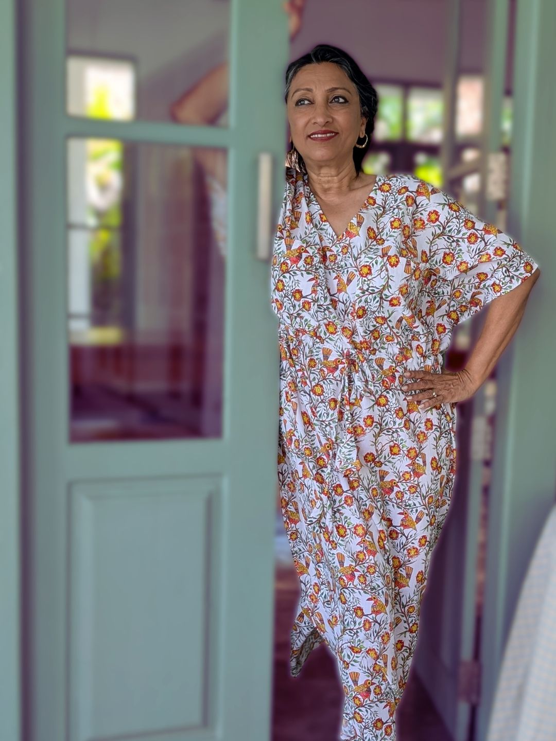 Woman wearing a floral nightdress cotton nghtie standing in a doorway