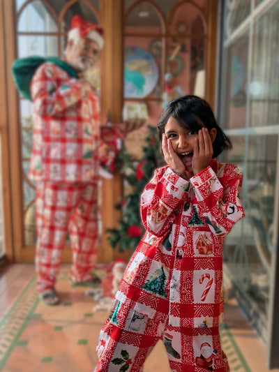 little girl wearing red christmas pajamas and waiting for santa claus