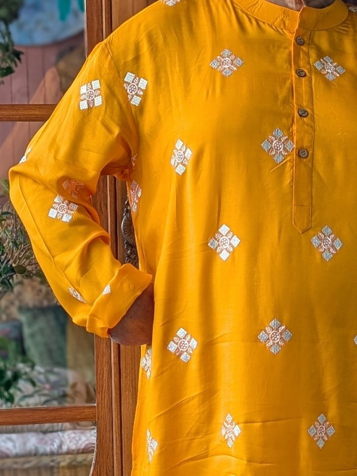 Yellow kurta with silver floral embroidery on a wooden door background