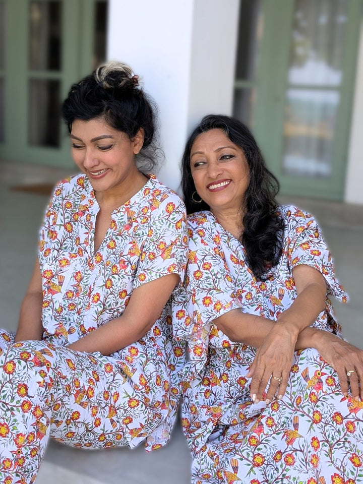 Two women sitting together wearing matching no bra night wear loungewear