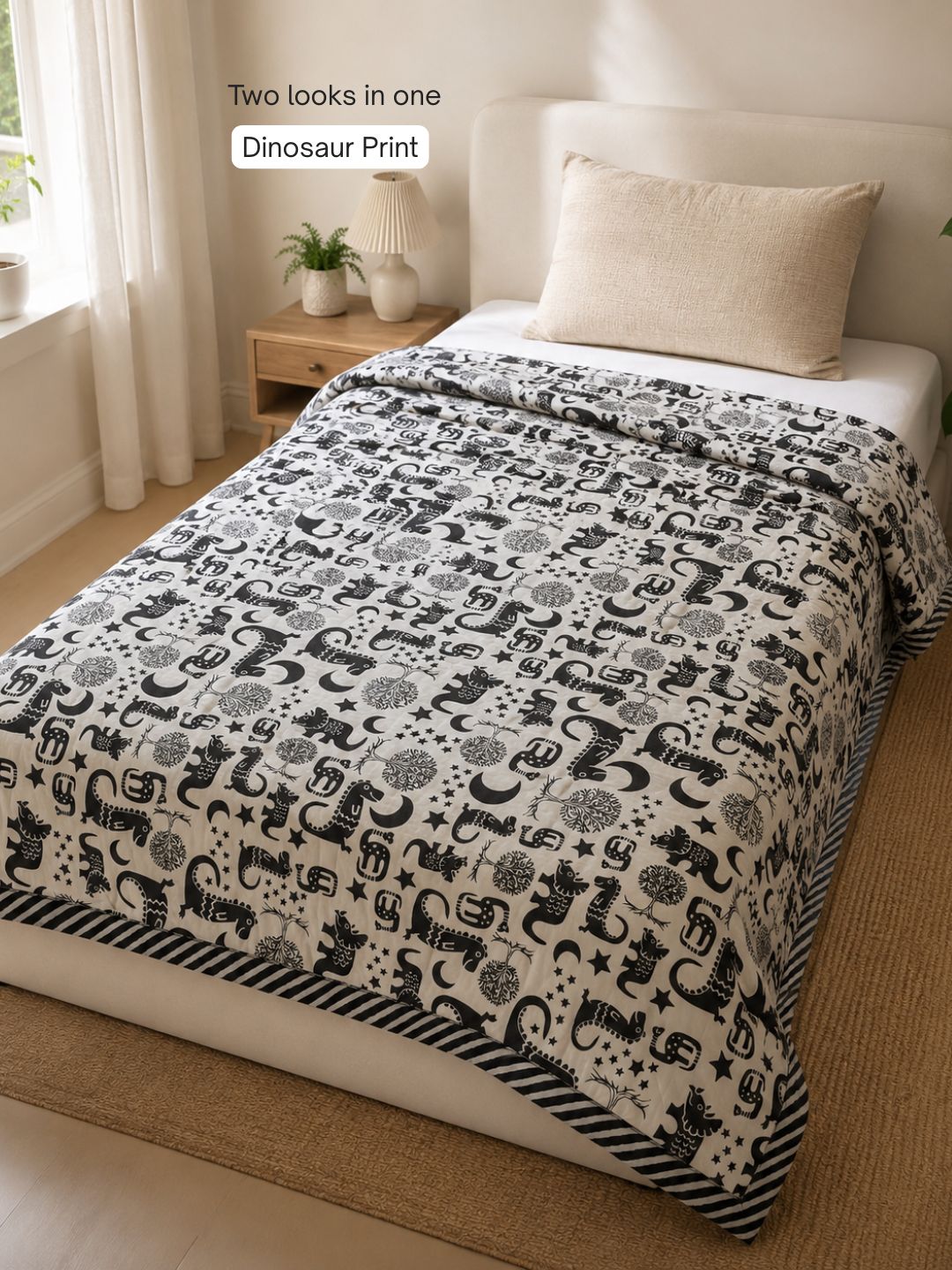 Dinosaur side of Tura Turi reversible muslin blanket - black folk-art dinosaurs, trees, moons and stars on cream cotton