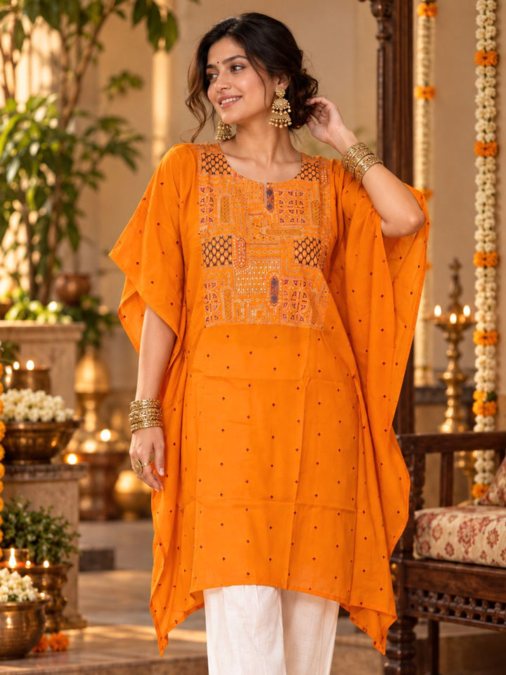 Woman in orange Utsav cupro silk kaftan with embroidered yoke, maroon buti and handkerchief hem, with off-white pants – photo 1 – Tura Turi