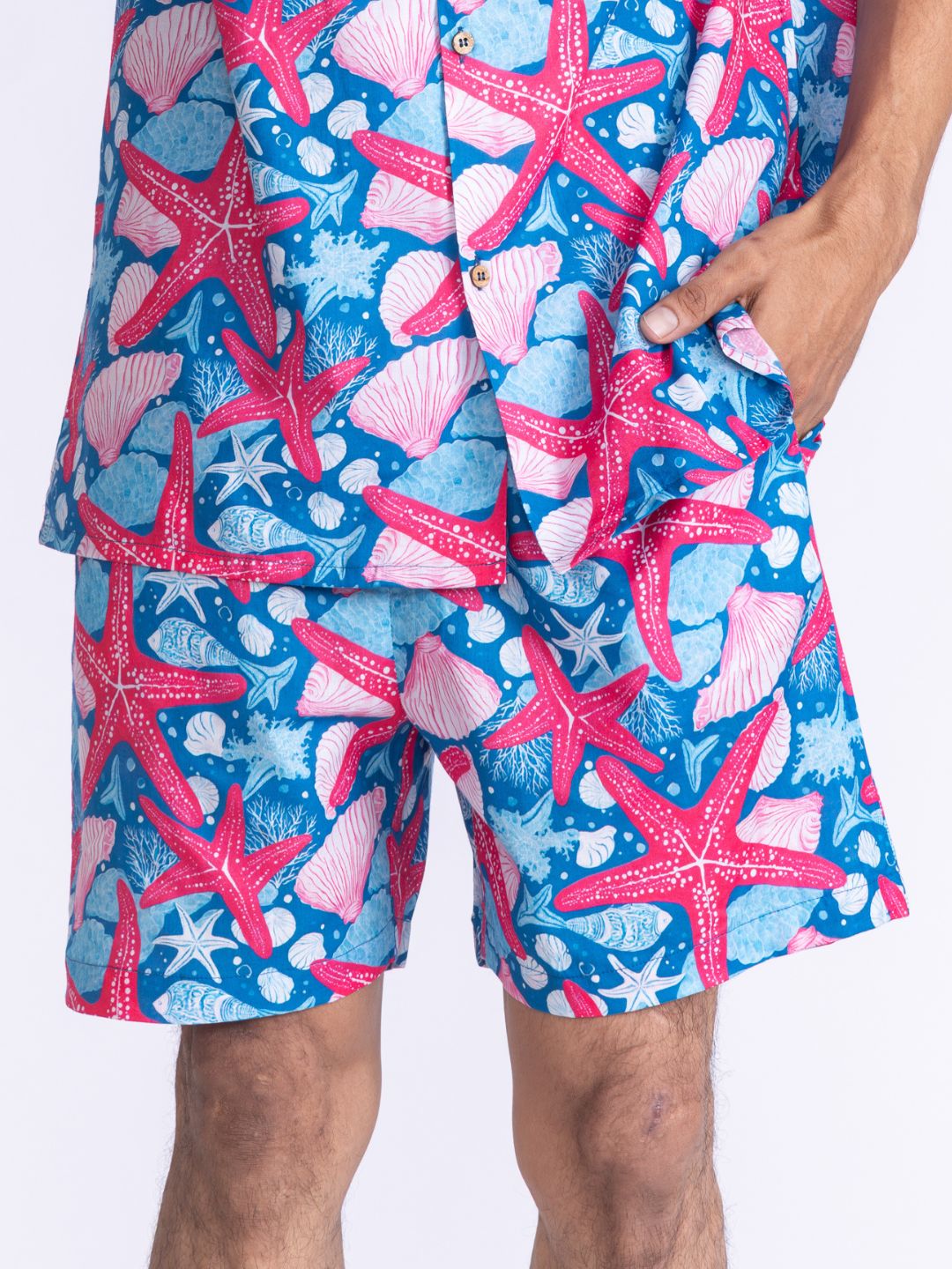 Blue and pink starfish patterned mens cotton shorts on a white background