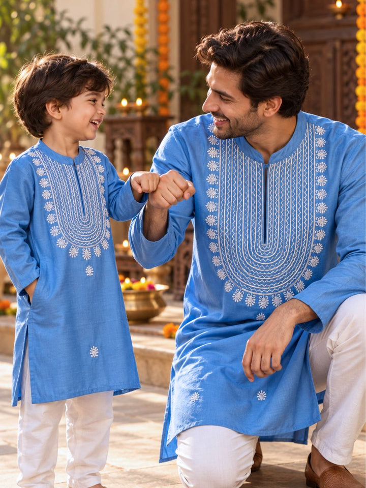Father son twinning in fashionable matching French blue cupro silk Tashan kurtas with white dramatic embroidery