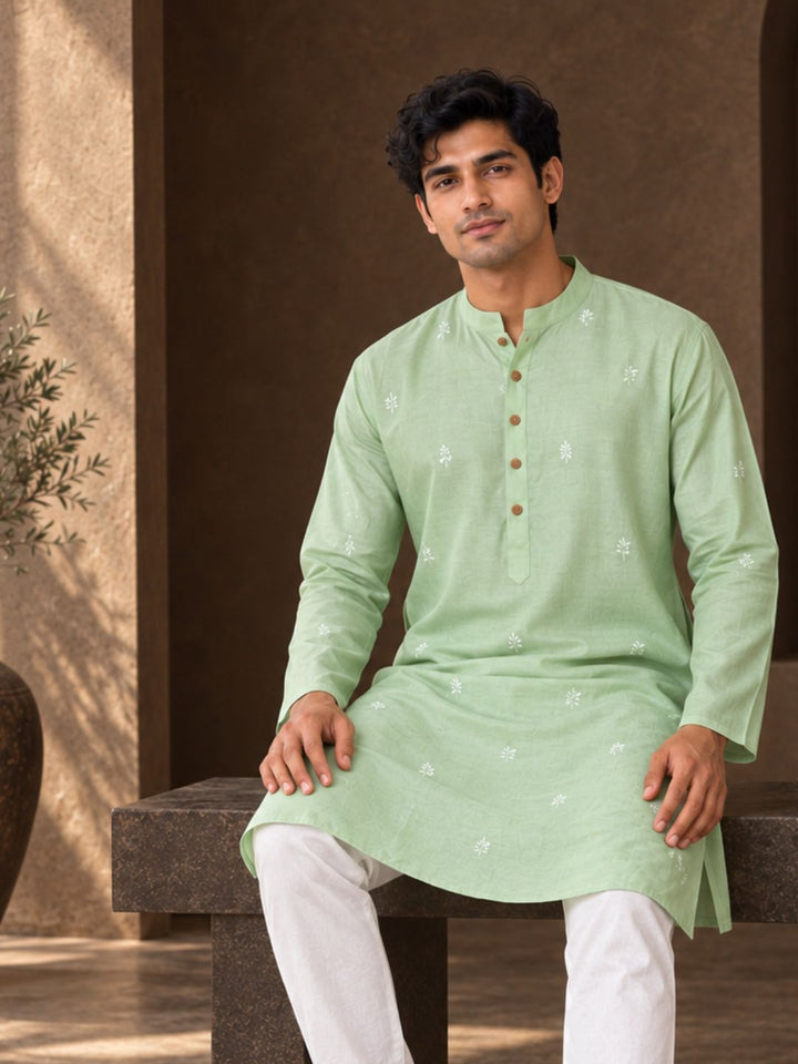 man sitting in jade green festive silk embroidered  kurta for men, breathable and soft. diwali and wedding wear for sangeet, mehendi functions
