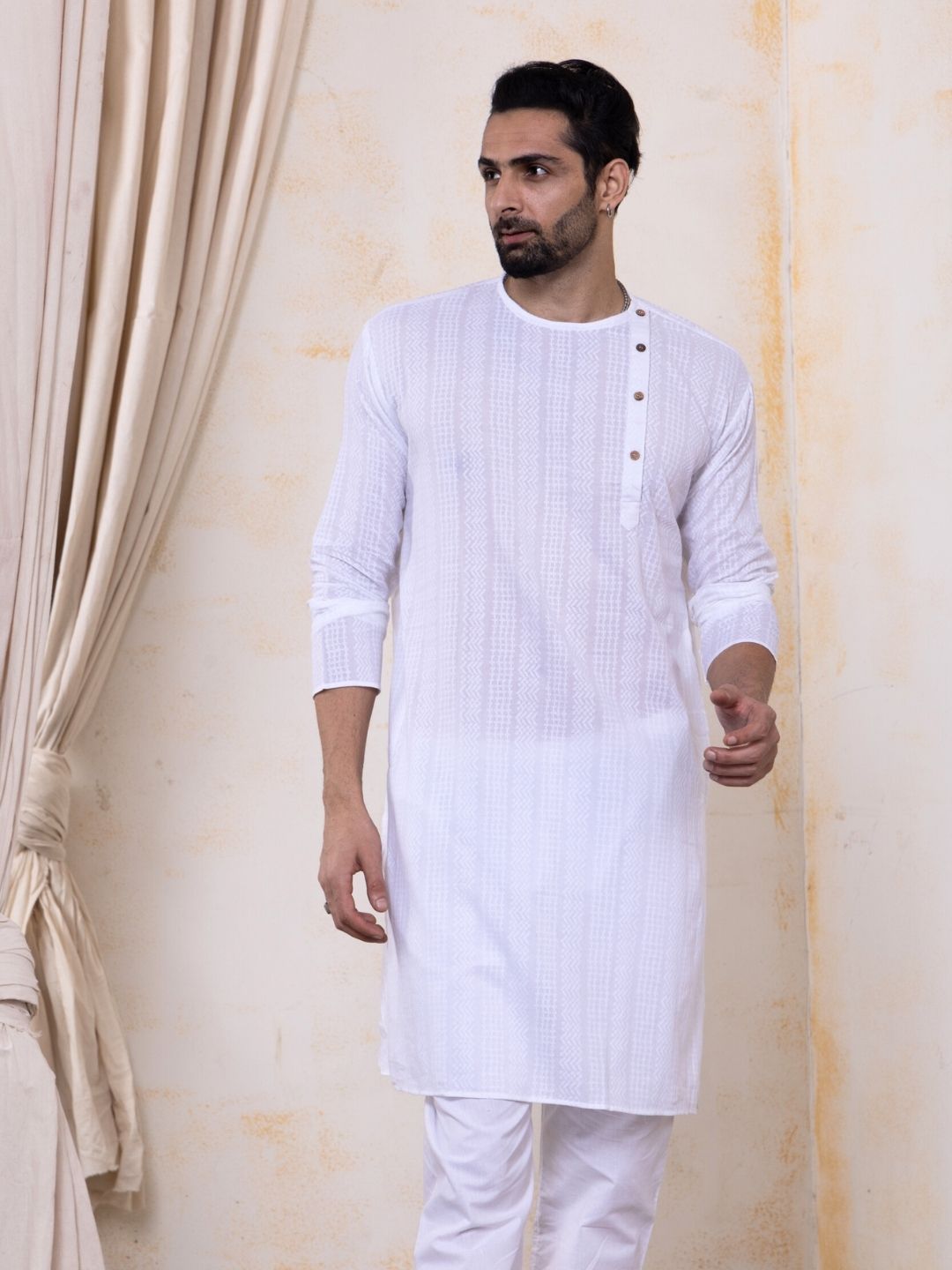 Man wearing a white kurta with a plain background