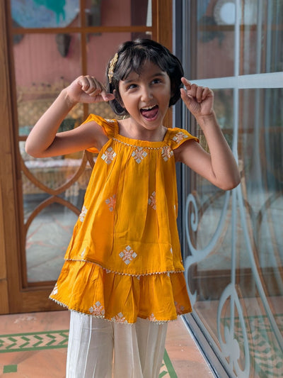 bright yellow silk kurta with afghan pants worn by a little girl
