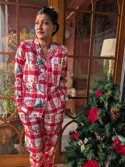 woman wearing a red and white checkered christmas themed nightsuit pajama set set in front of a decorated Christmas tree.