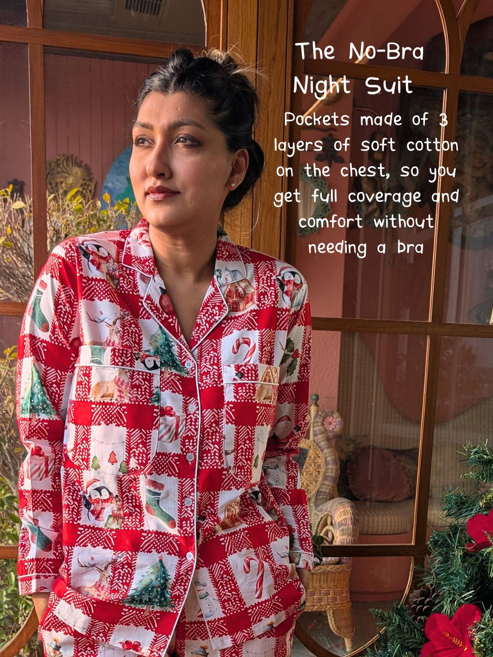 Woman wearing a red night suit with festive patterns, standing in a room with decorative elements. top has 4 layered pockets to wear without a bra and gives full nipple coverage