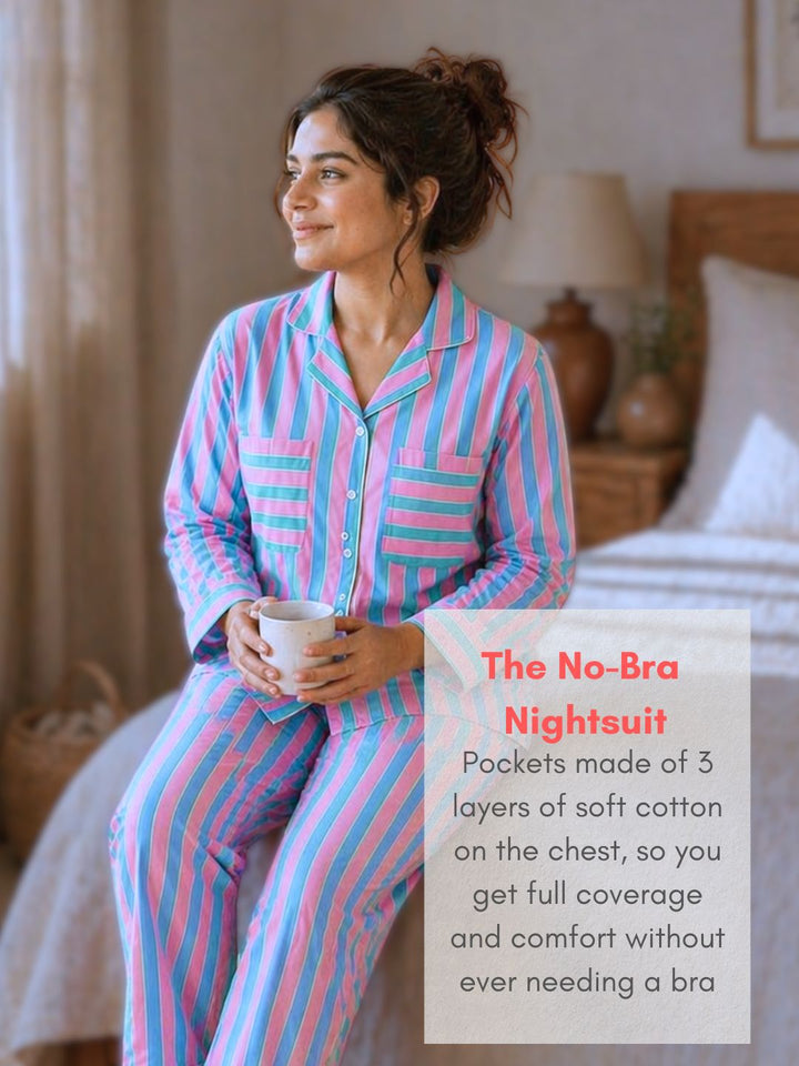 Woman wearing a pink and blue striped no-bra nightsuit sitting on a bed.