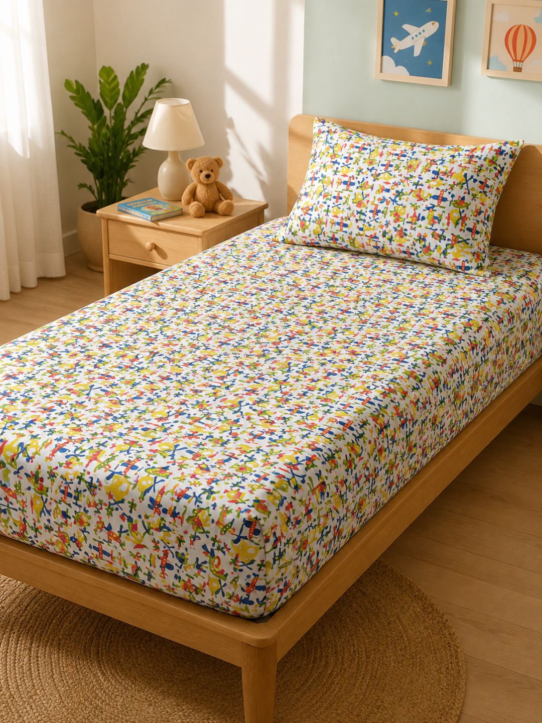 Colourful airplane and helicopter print cotton bedsheet for kids, styled on a single bed with matching pillow cover.
