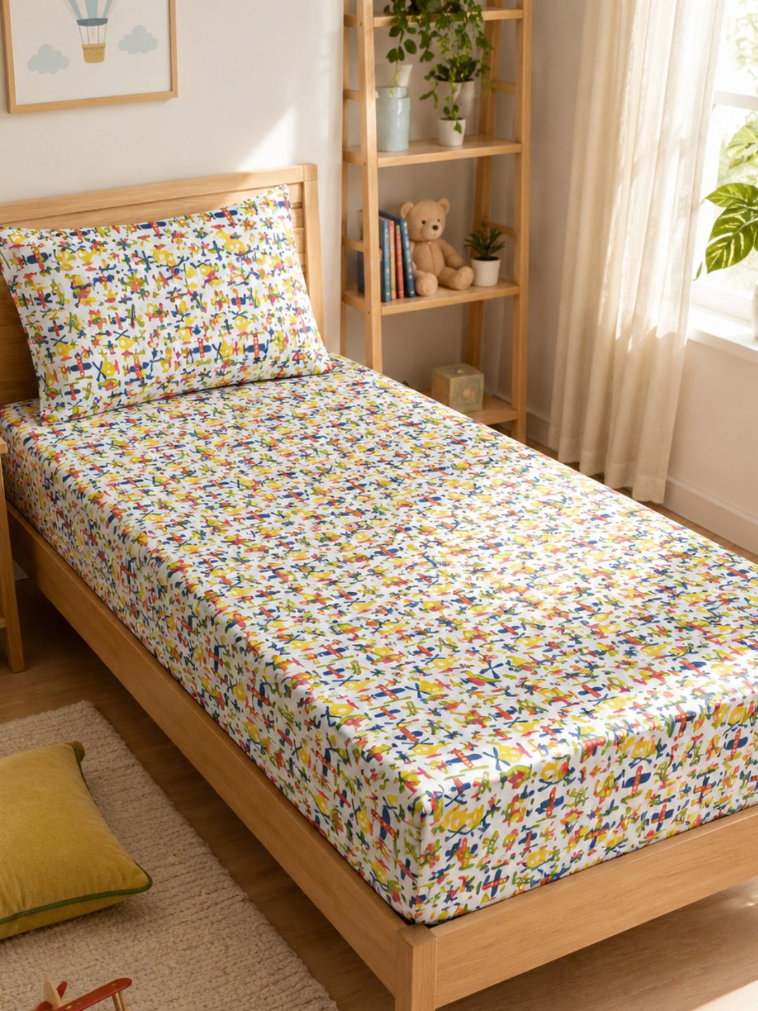 Cotton single bedsheet and pillowcase with playful aircraft print for boys and girls, styled in a cosy kids room.