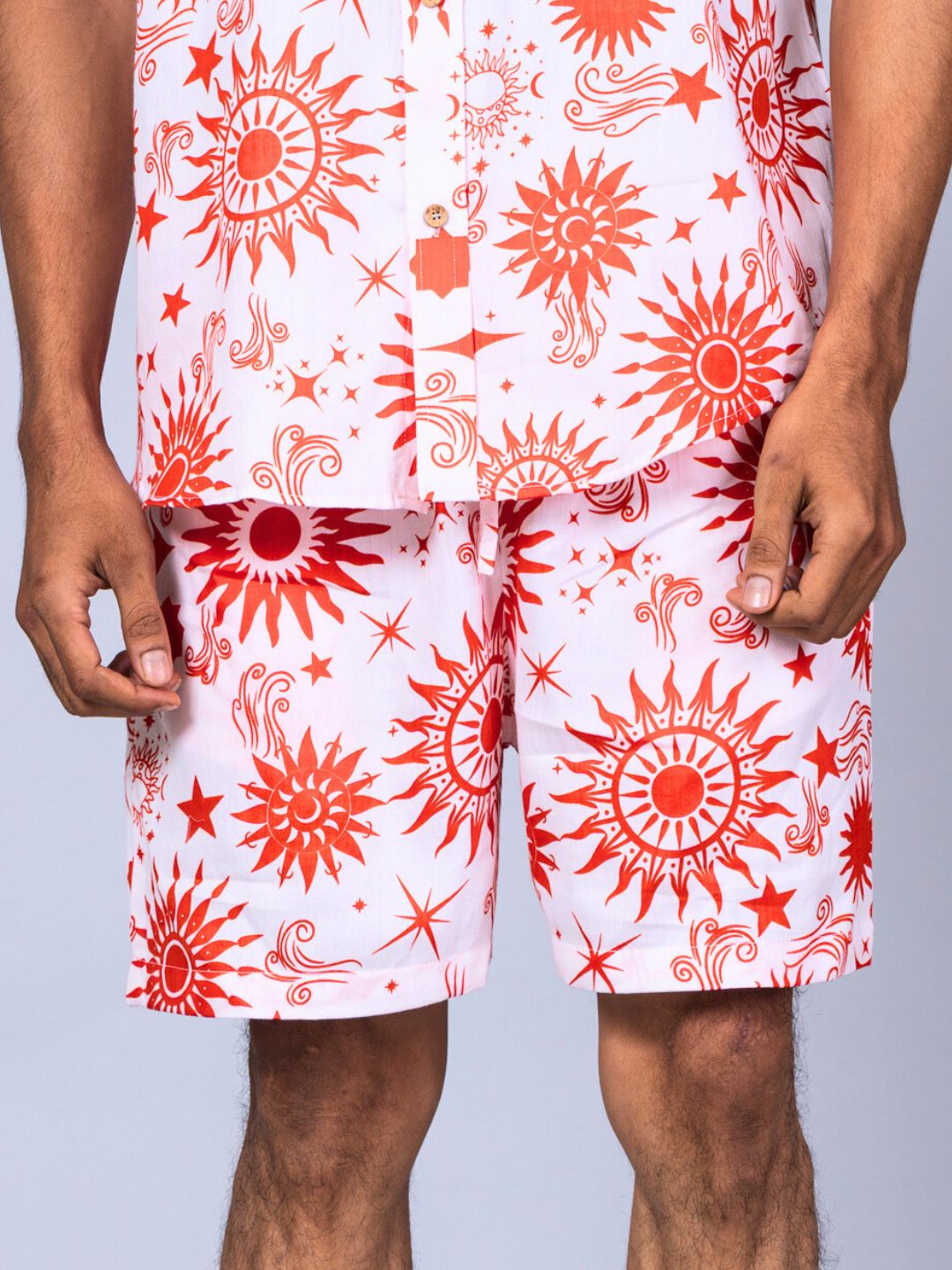 Man wearing a pair of men's white shorts with red pattern 