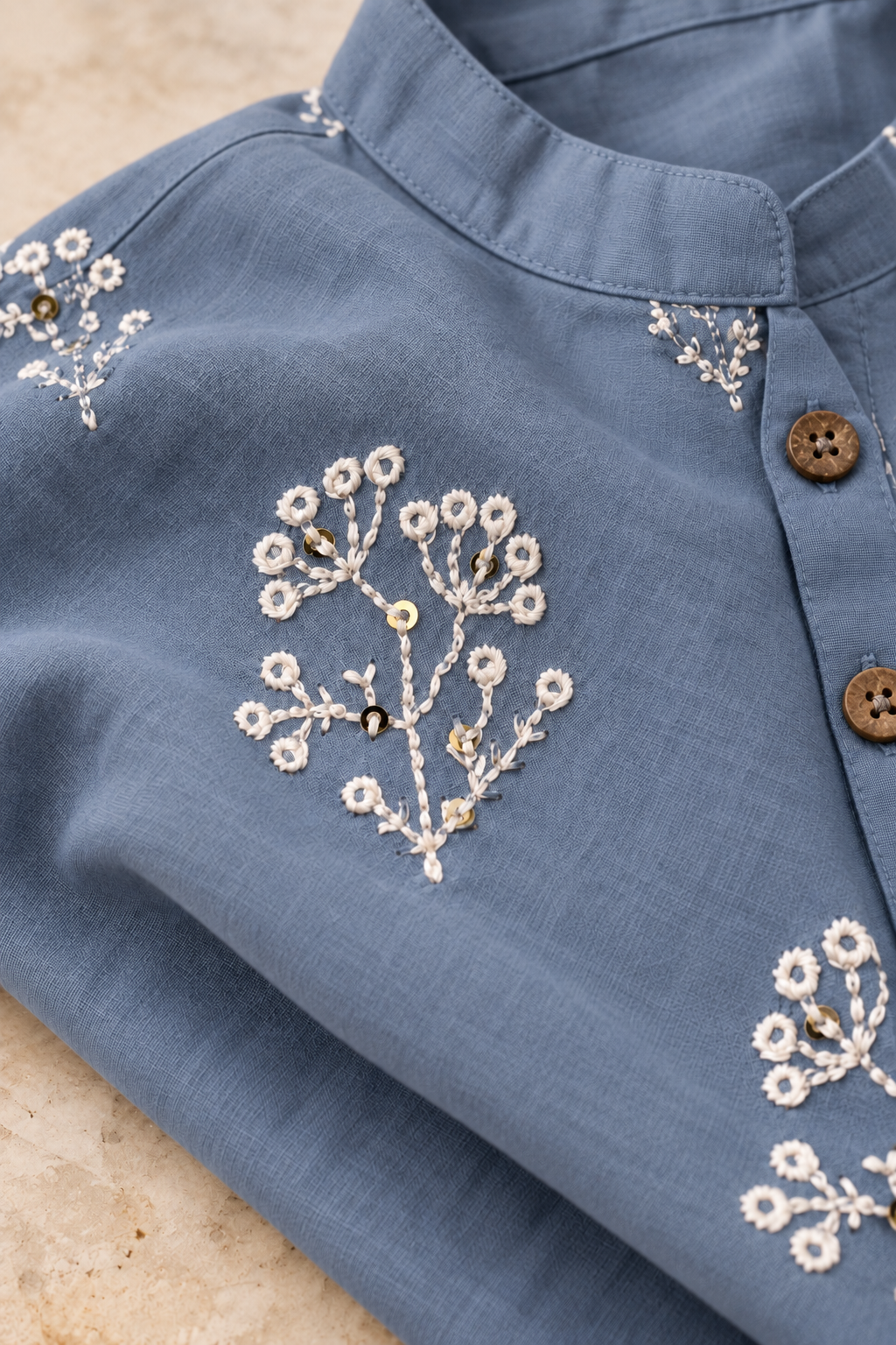 close up of beautiful sequinned resham white embroidery on grey kurta