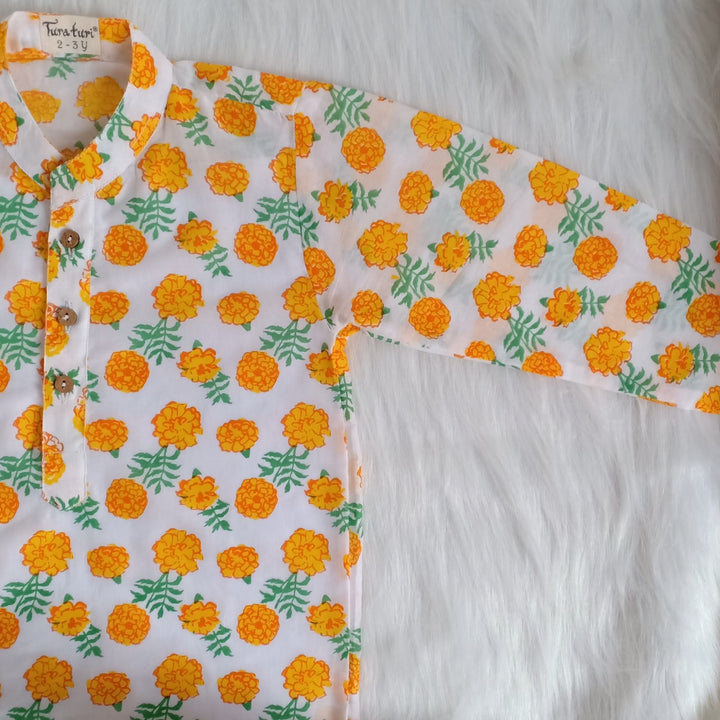 Marigold print malmal kurta laid flat showing wooden button placket